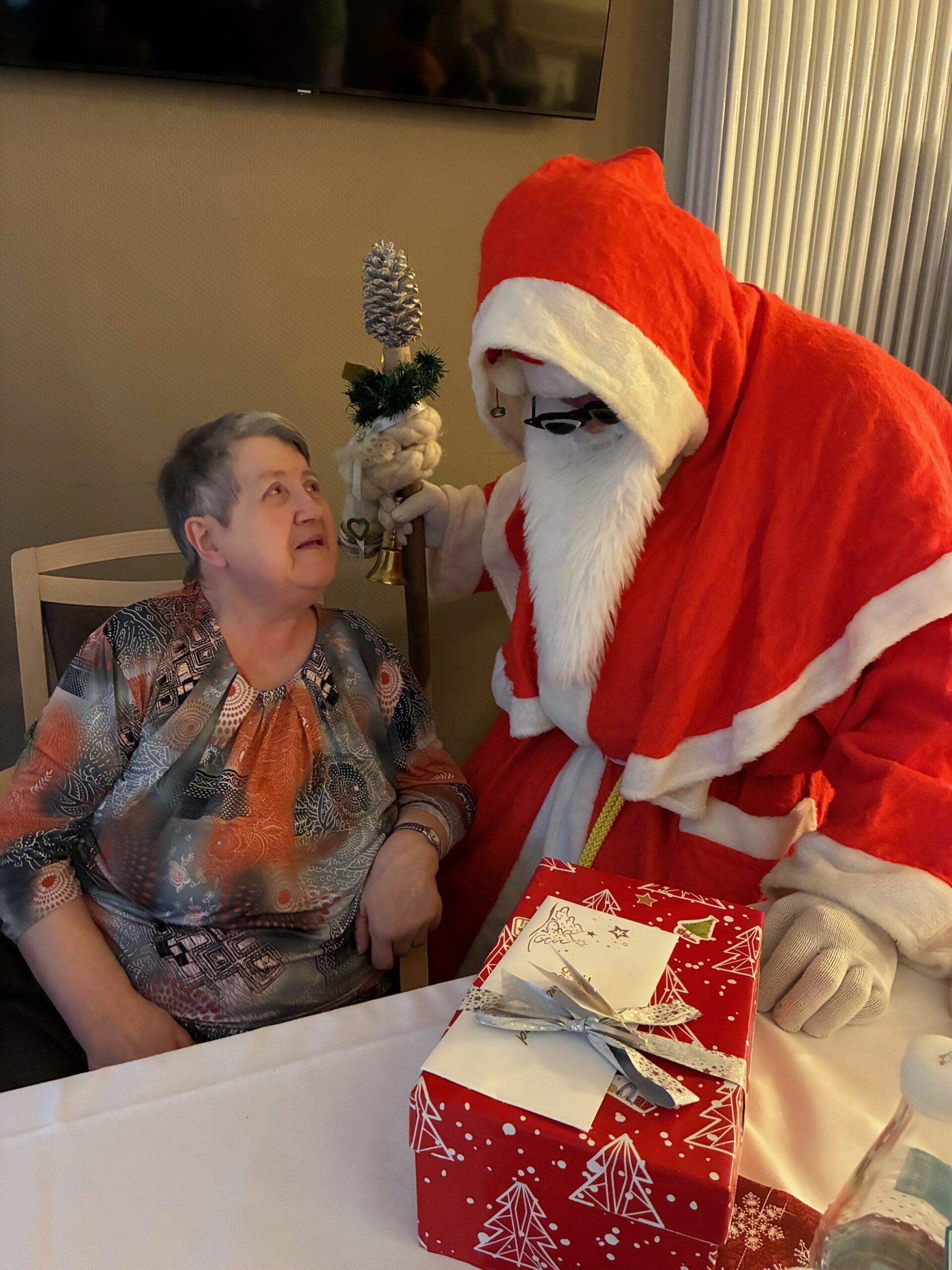 der Weihnachtsmann überreicht einer Bewohnerin ein Geschenk