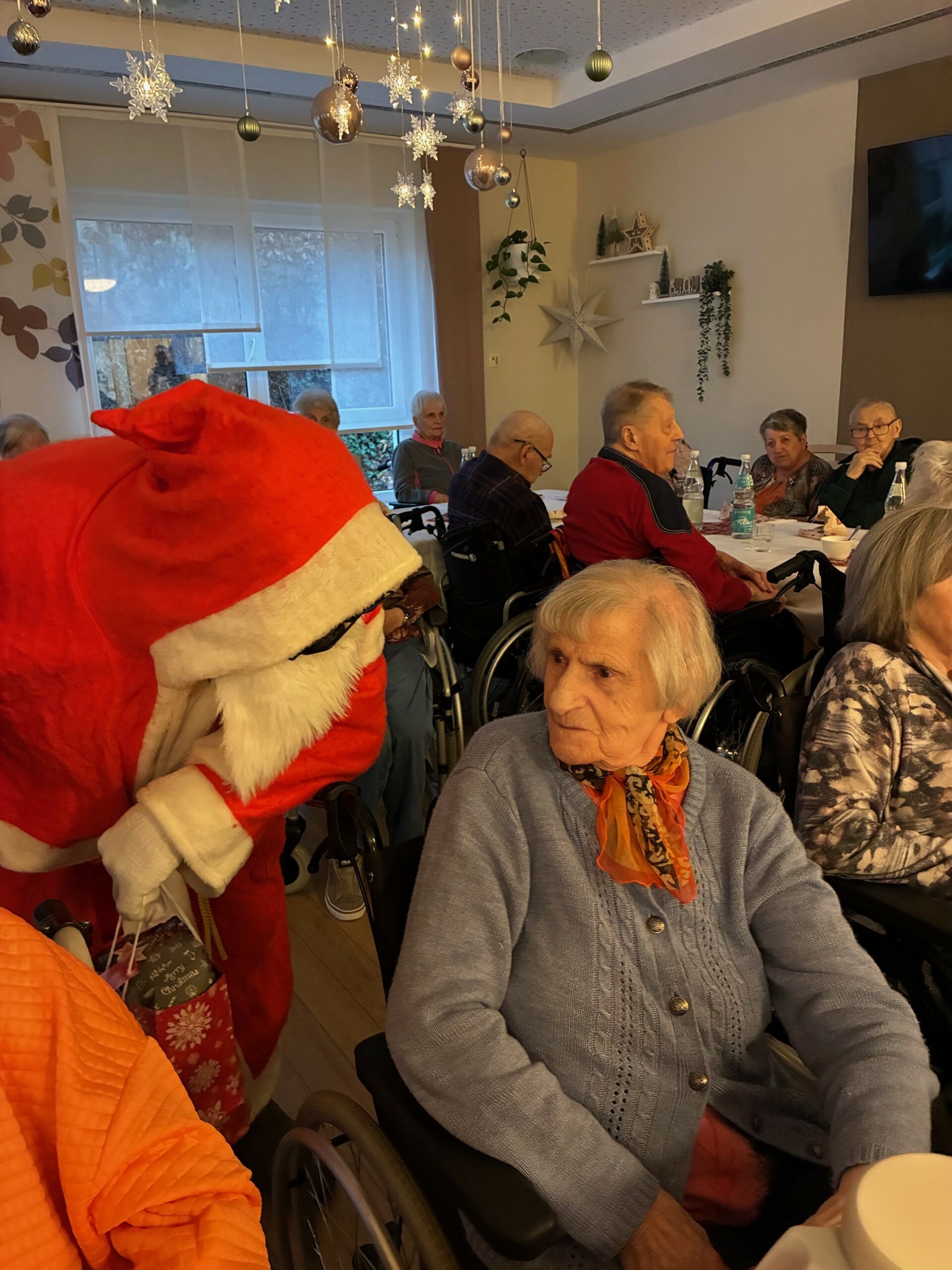 der Weihnachtsmann überreicht den Bewohner*innen Geschenke