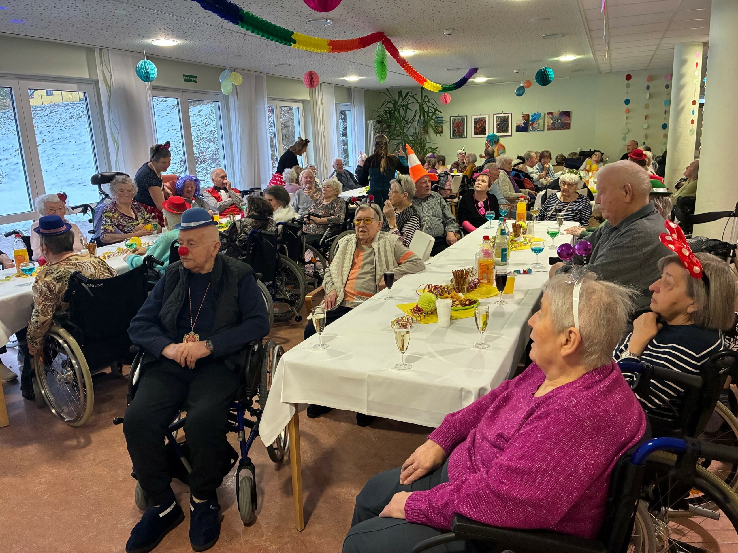 die Bewohner*innen im geschmückten Partyraum